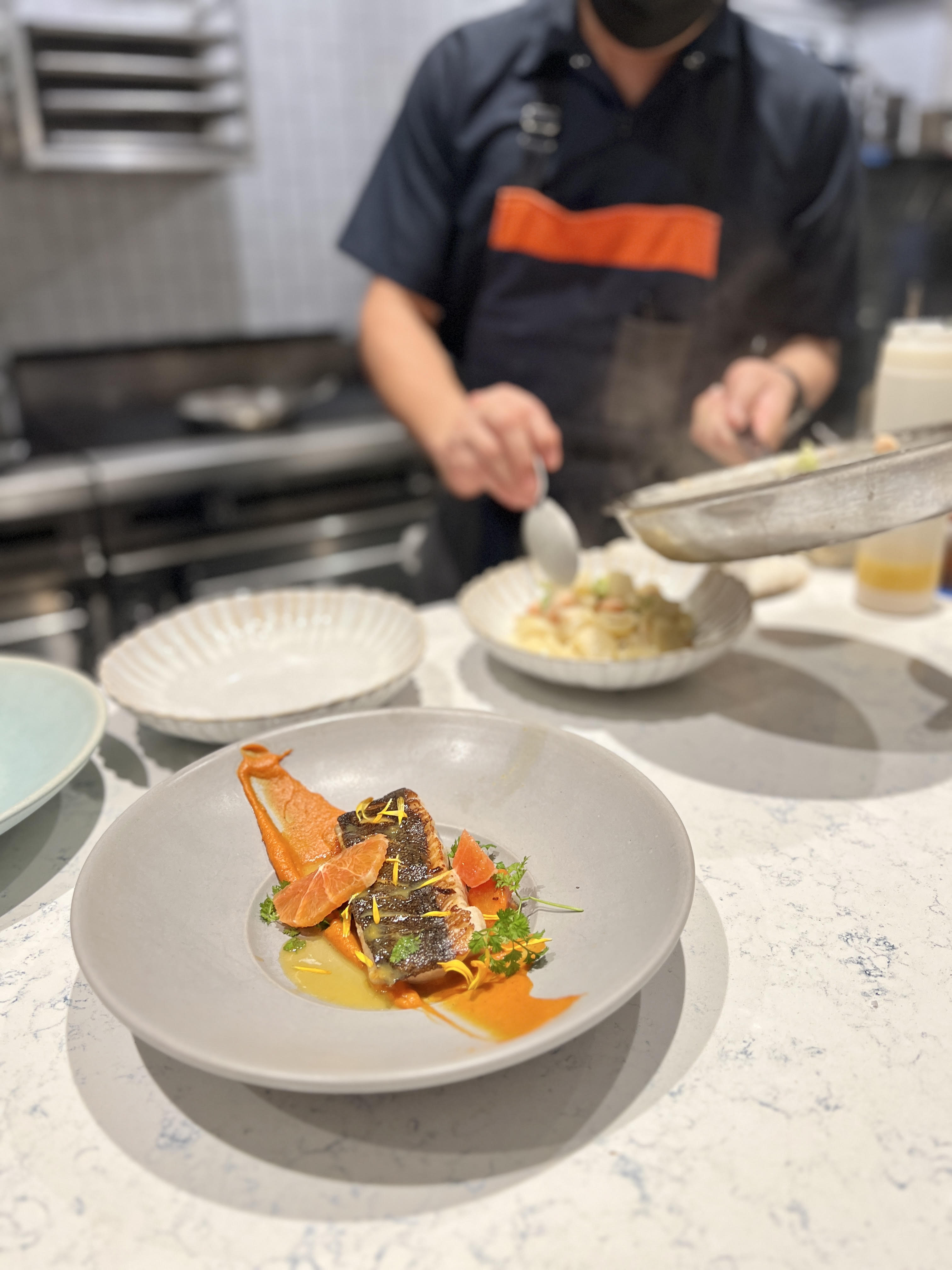 A cook preparing dishes at Cassava