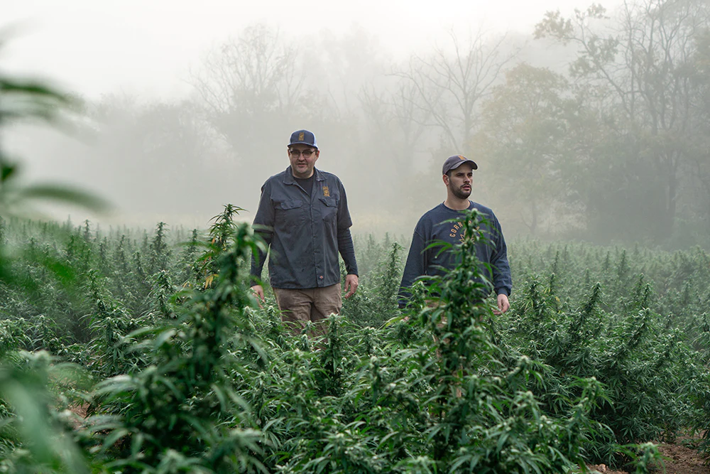 Players dressed in Minnesota Aurora FC’s turquoise jerseys in a huddle during a game in front of spectators in the stadium