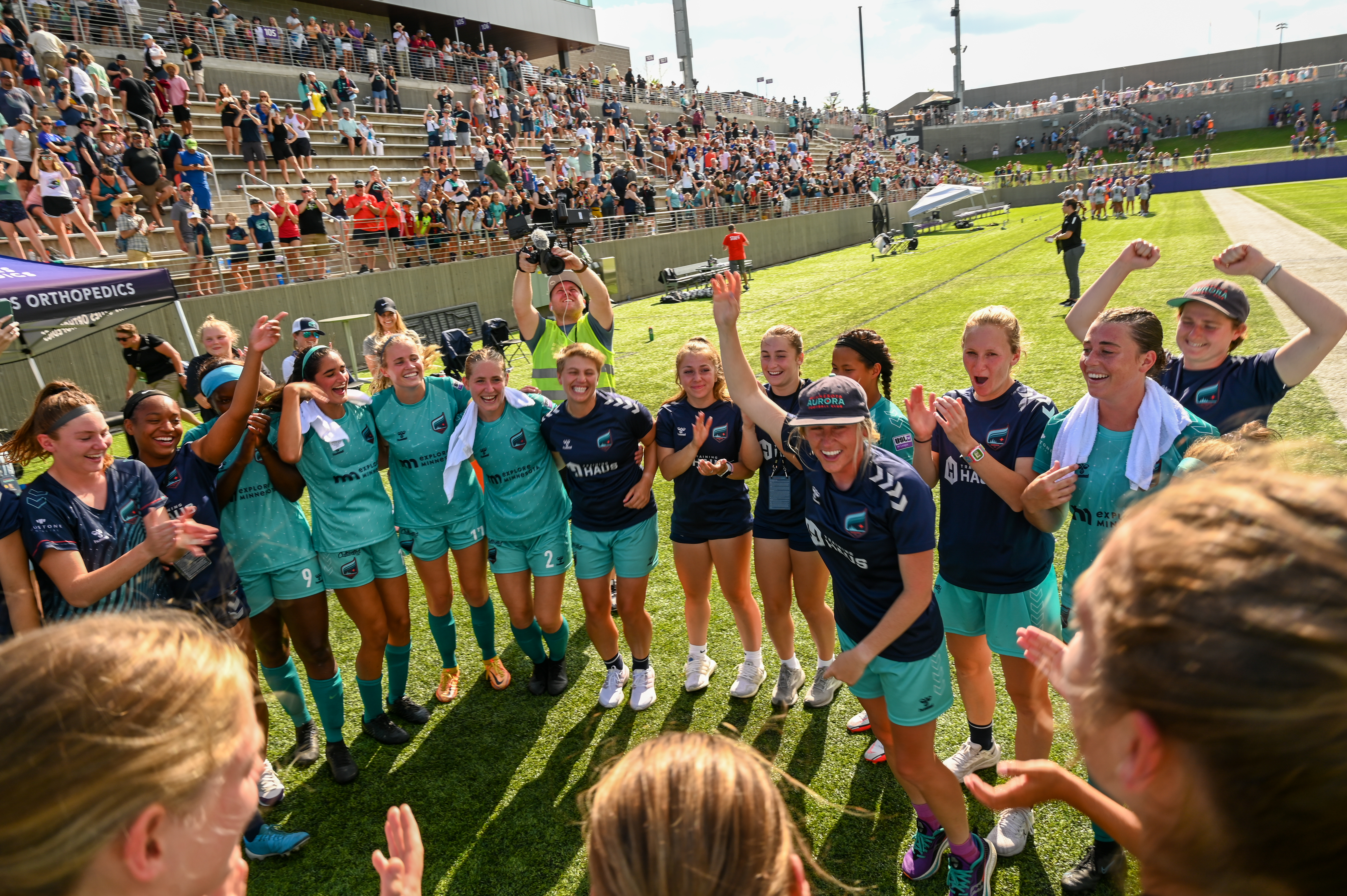 Minnesota Aurora's head coach Nicole Lukic leads the team in a post-game celebration.